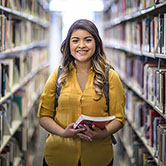 Student inside the library with a book