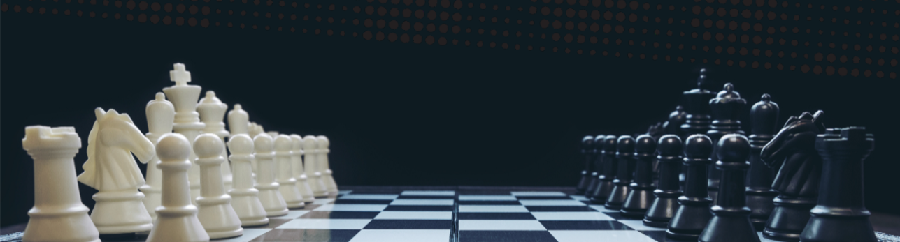 A chessboard with white and black pieces set for a game. Pieces are aligned, creating a tense, strategic atmosphere against a dark background.