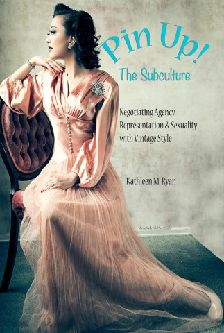 Elegant woman in vintage pink dress sits on antique chair in a poised, contemplative pose. Text on the image reads “Pin Up! The Subculture” by Kathleen M. Ryan, exploring themes of agency and sexuality.