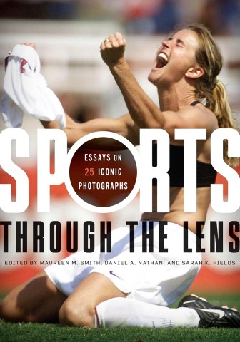A woman athlete celebrates passionately on a field, holding her jersey in the air. The cover of a book titled "Sports Through the Lens" overlays the image.