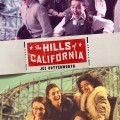 Two groups of people ride a wooden roller coaster, joyfully screaming. The ride is set against a clear blue sky. Text reads 'The Hills of California' by Jez Butterworth, with a vintage, adventurous tone