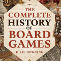 Cover of "The Complete History of Board Games" by Julie Downing. It displays chess pieces and vintage board games, conveying a historical and nostalgic tone.